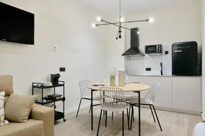 a living room with a table and chairs and a kitchen at Romantic Apartment N5 Oceanografico Virkin Suites in Valencia