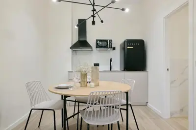 a kitchen with a table and chairs and a refrigerator at Romantic Apartment N5 Oceanografico Virkin Suites in Valencia