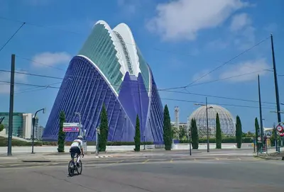 a person riding a bike in front of a building at Romantic Apartment N6 Oceanografico Virkin Suites in Valencia