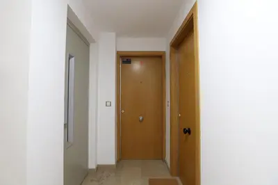 a hallway with a wooden door in a building at Tranquilo y delicioso rincón junto al mar in Puerto de Sagunto