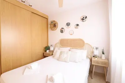 a bedroom with a white bed with a wooden headboard at Tranquilo y delicioso rincón junto al mar in Puerto de Sagunto