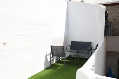 two chairs and a table in a room with grass at Tradición y modernidad Casa de pueblo junto al mar in Puerto de Sagunto