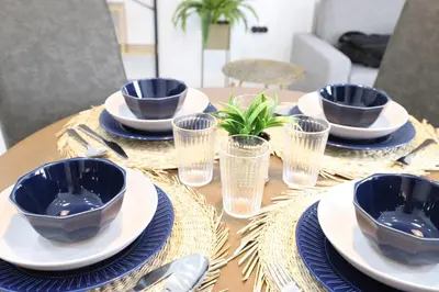 a table with blue bowls and plates on it at Deslumbrante y familiar casa cerca de la playa in Puerto de Sagunto