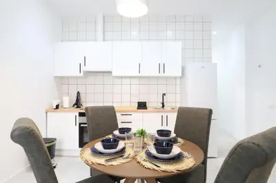 a kitchen with a wooden table with chairs and a tableasteryasteryasteryasteryastery at Deslumbrante y familiar casa cerca de la playa in Puerto de Sagunto