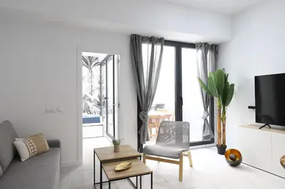 a living room with a couch and a chair and a window at Deslumbrante y familiar casa cerca de la playa in Puerto de Sagunto