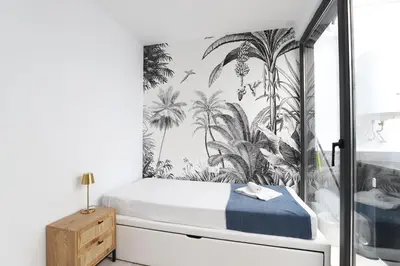 a bedroom with a bed with palm trees wallpaper at Deslumbrante y familiar casa cerca de la playa in Puerto de Sagunto