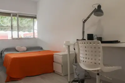 a bedroom with a bed and a desk and a lamp at Flat close to beach perfect for families and groups - Actor Mauri 18 in Valencia