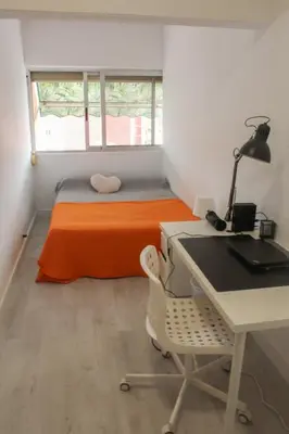 a bedroom with a bed with an orange blanket and a desk at Flat close to beach perfect for families and groups - Actor Mauri 18 in Valencia