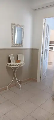 a white room with a table and a mirror at Apartamento Premium frente al mar, en primera linea de playa in Cullera