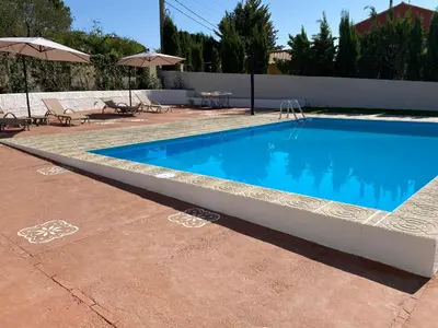 a swimming pool in a patio with umbrellas at Rey Elzinga in Godelleta