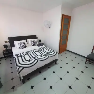 a bedroom with a bed with a black and white floor at Casa Central in Cullera