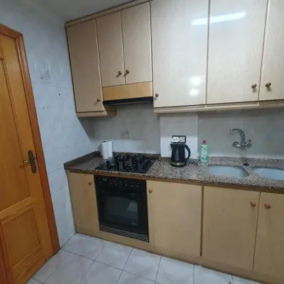 a small kitchen with a stove and a sink at Casa Central in Cullera