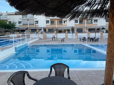 a swimming pool with two chairs and a table at Valencia Sun House in Puebla de Farnals