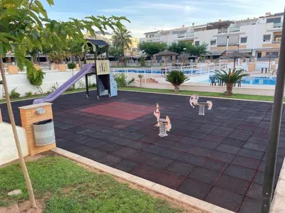 a playground with two children playing on a slide at Valencia Sun House in Puebla de Farnals