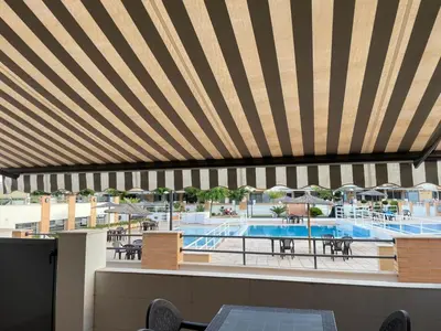 a view of the pool at a resort with a striped ceiling at Valencia Sun House in Puebla de Farnals
