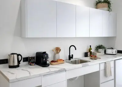 a kitchen with white cabinets and a microwave at Avakian Suite Valencia in Valencia
