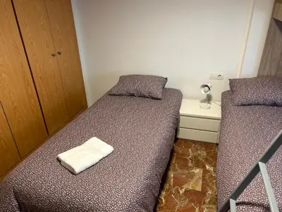 a small bedroom with two beds and a night stand at ISABEL Apartment in Puerto de Sagunto