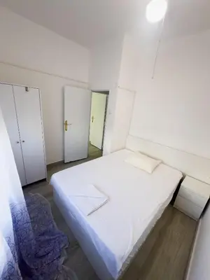 a small bedroom with a white bed and two doors at Mar y Puerto in Puerto de Sagunto