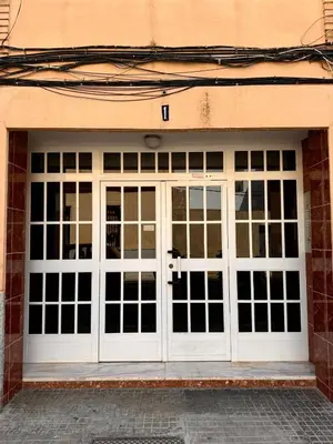 a garage with white doors on a brick building at Cozy Flat with City & Beach in Puerto de Sagunto