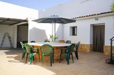 a table and chairs with an umbrella on a patio at casa imperial in Tous