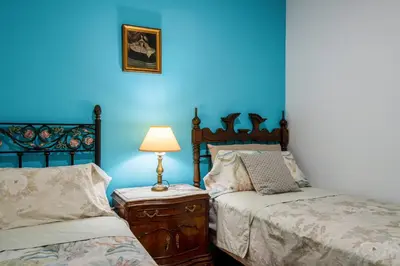 a bedroom with two beds and a blue wall at Mirador 5 del Mercado Central - habitacion con baño privado en el centro de la Ciudad Vella in Valencia