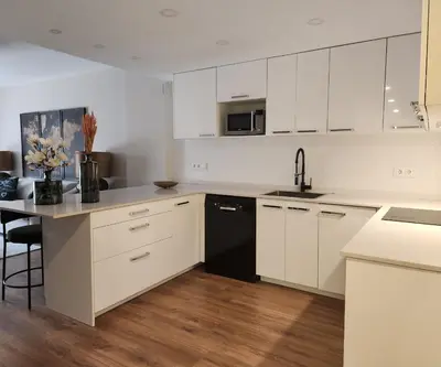 a kitchen with white cabinets and a black refrigerator at MD Malva Valterna in Paterna