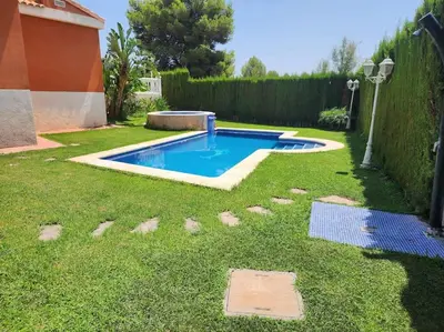 a small swimming pool in a yard with grass at Casa Villa Molins in Valencia