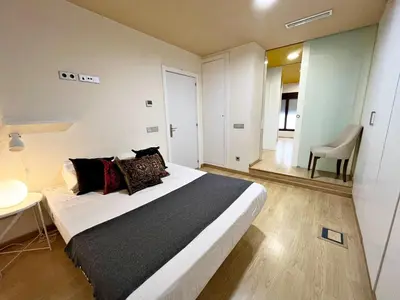 a bedroom with a bed and a table and a mirror at Apartamento junto Mercado Central Valencia in Valencia