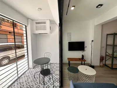a room with a balcony with a table and chairs at Alberola Industrial Style in Valencia
