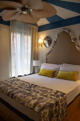 a bedroom with a large bed with a ceiling fan at Maison Primado B&B in Valencia
