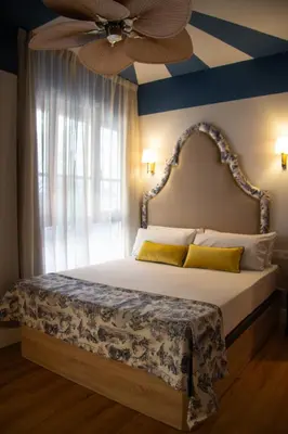 a bedroom with a bed with a ceiling fan at Maison Primado B&B in Valencia