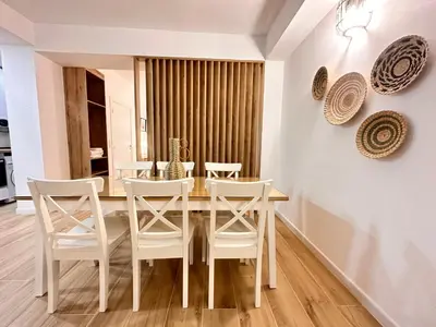 a dining room with a table and white chairs at Valencia & Suites Ayora in Valencia