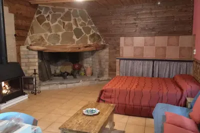 a living room with a bed and a fireplace at La Traviesa in Soneja