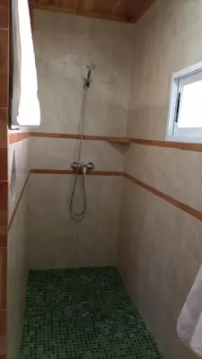 a bathroom with a shower with a green tile floor at La Traviesa in Soneja