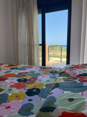 a bed with a colorful comforter and a window at Almenara, primera linea de playa VT-45077-CS in Almenara