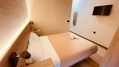 a small room with a bed and a tv at OPTIMUS COMFORT Campoamor 101 in Valencia