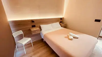 a small bedroom with a bed and a chair at OPTIMUS COMFORT Campoamor 101 in Valencia