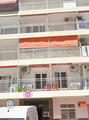 a building with balconies and a bus parked in front of it at Seashell apartment in Cullera in Cullera