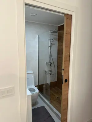 a bathroom with a toilet and a glass shower at Del Mar 1A - New Beach First floor apartment in Puerto de Sagunto