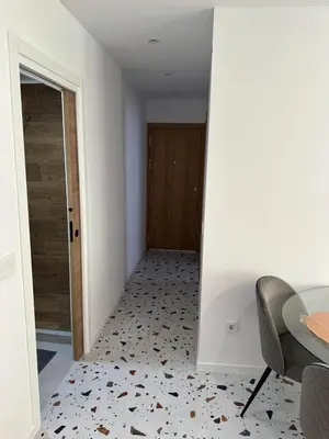a hallway with a table and a chair and a door at Del Mar 1A - New Beach First floor apartment in Puerto de Sagunto