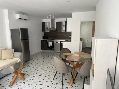 a kitchen and living room with a table and chairs at Del Mar 1A - New Beach First floor apartment in Puerto de Sagunto