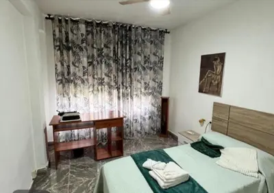 a bedroom with two beds and a desk and a window at Apartamento en la Sierra Espadan in Artana