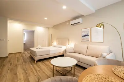 a living room with a couch and a bed at Cortes Suites by Concept Flats in Valencia