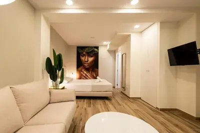 a living room with a bed and a painting of a woman at Cortes Suites by Concept Flats in Valencia
