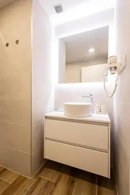 a bathroom with a sink and a mirror at Cortes Suites by Concept Flats in Valencia