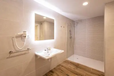 a bathroom with a sink and a shower at Cortes Suites by Concept Flats in Valencia