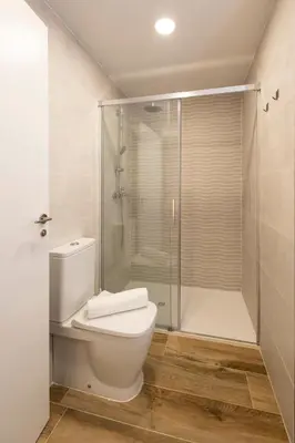 a bathroom with a toilet and a shower at Cortes Suites by Concept Flats in Valencia
