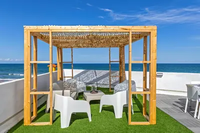 a gazebo with chairs and a table on a deck at ViDa MaLu - Housevanlive in Sueca