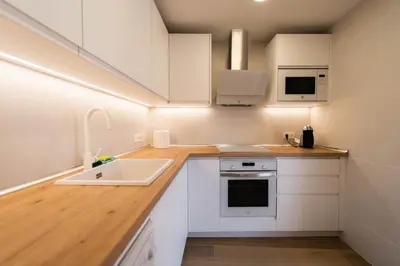 a kitchen with white cabinets and a sink at Apartamento acogedor en la Playa de Nules in Nules