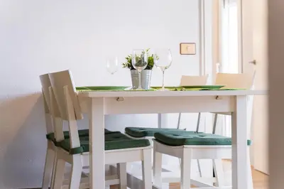 a white dining room table with green cushioned chairs at Apartamento acogedor en la Playa de Nules in Nules